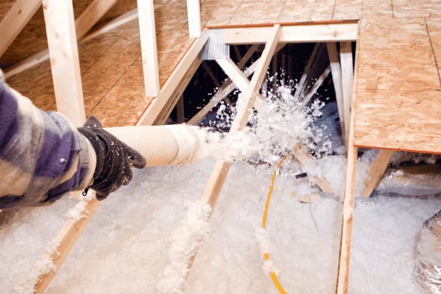 Blown-in insulation spread across an attic floor between the joists