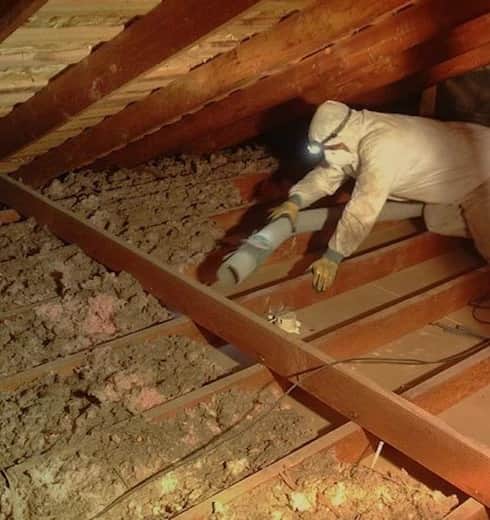 Attic with old blown-in insulation and ductwork before removal